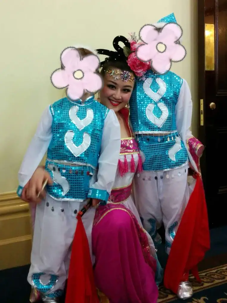 Raina with two children in traditional costumes