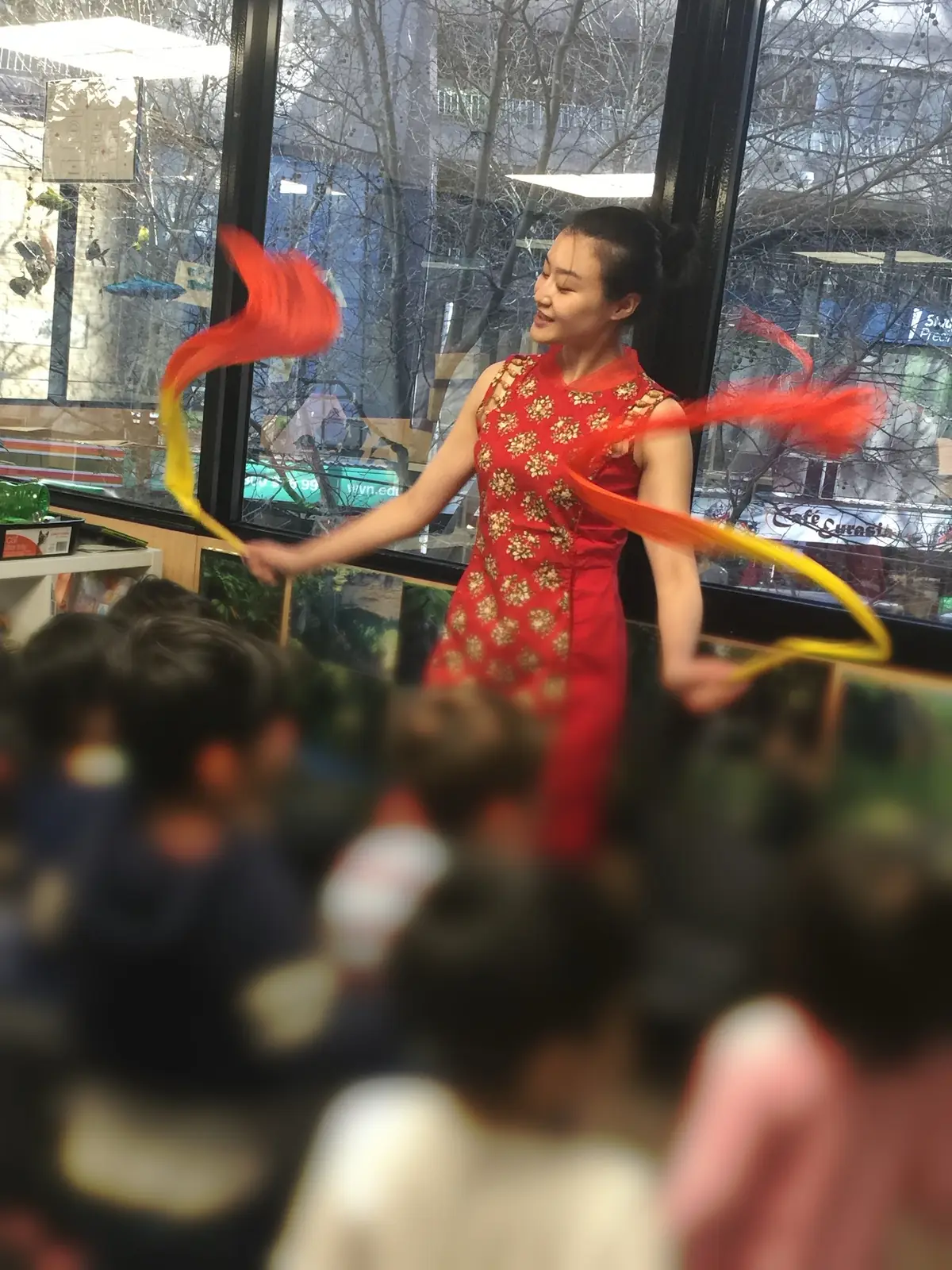 Raina dancing with silk ribbons for a group of children