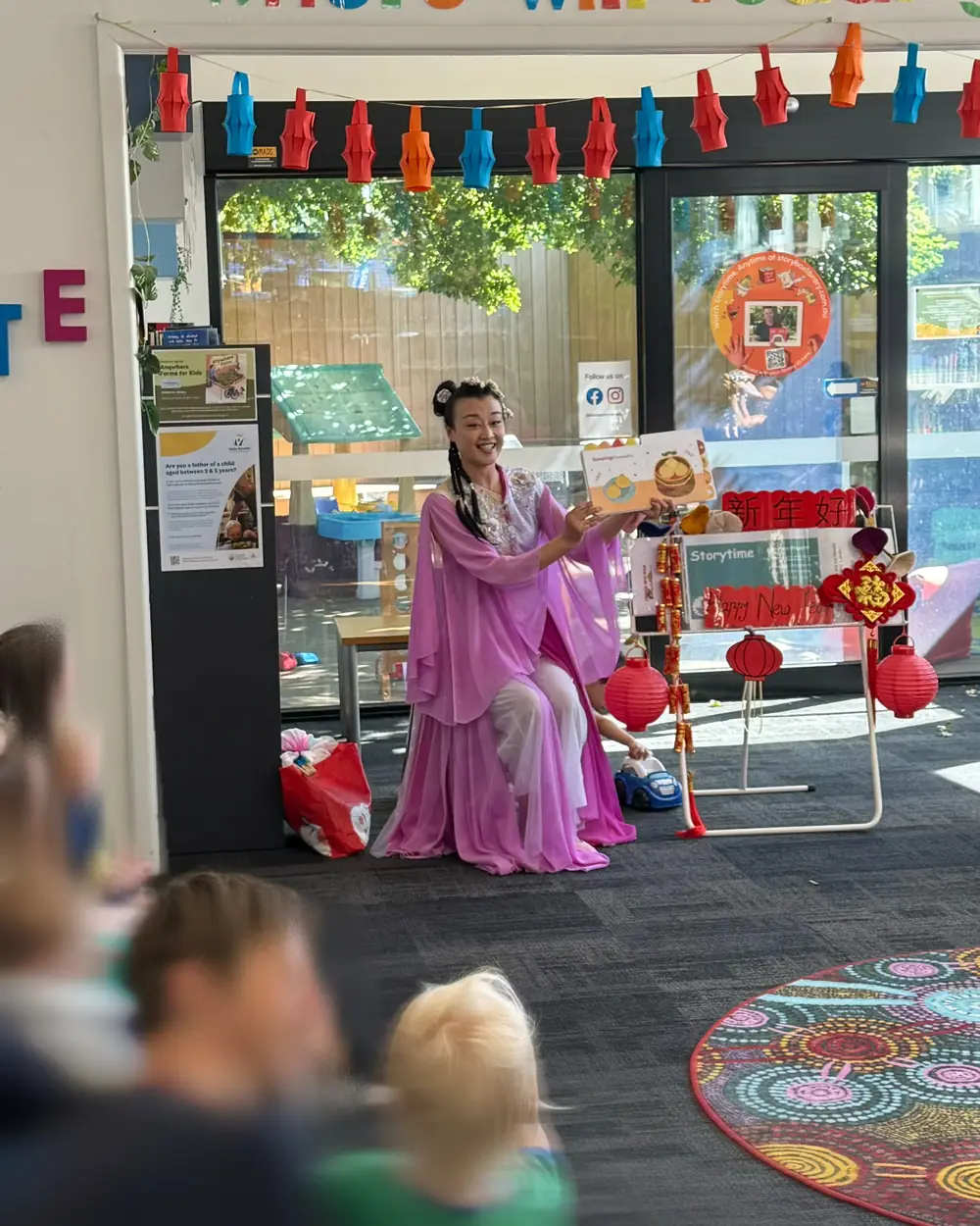 Raina reading a story to children at a library