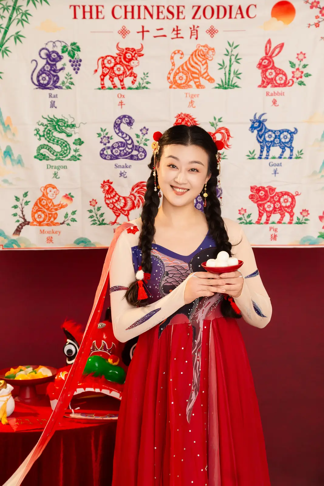 Raina smiling in a red festival outfit