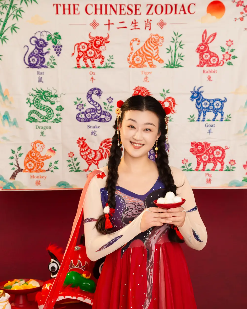 Raina smiling in a red festival outfit, ready for Chinese New Year