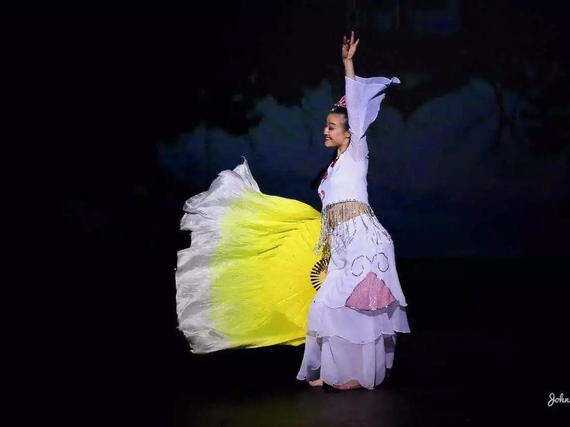 Raina performing a Chinese fan dance on stage