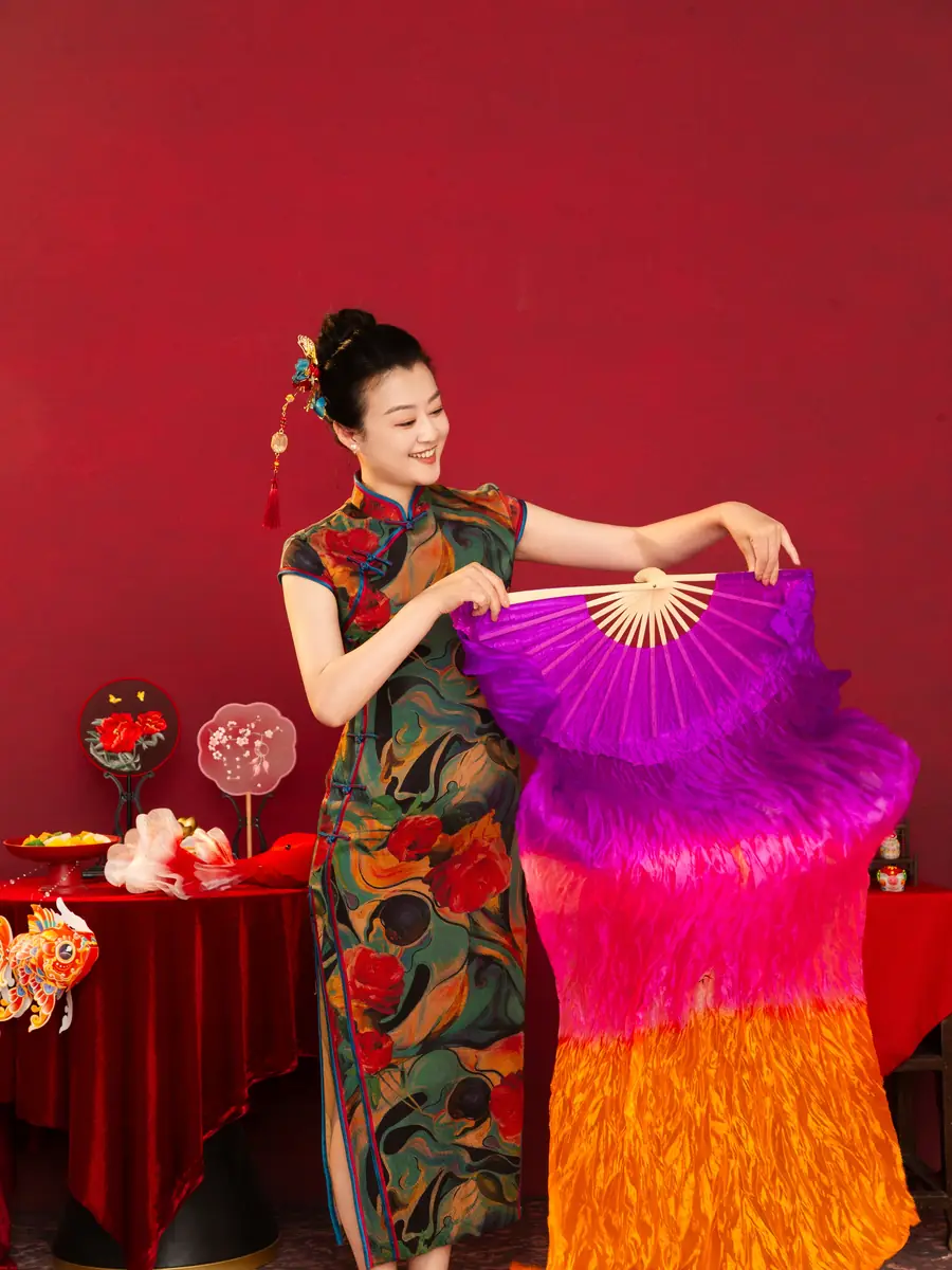 Raina dancing with a large purple silk fan