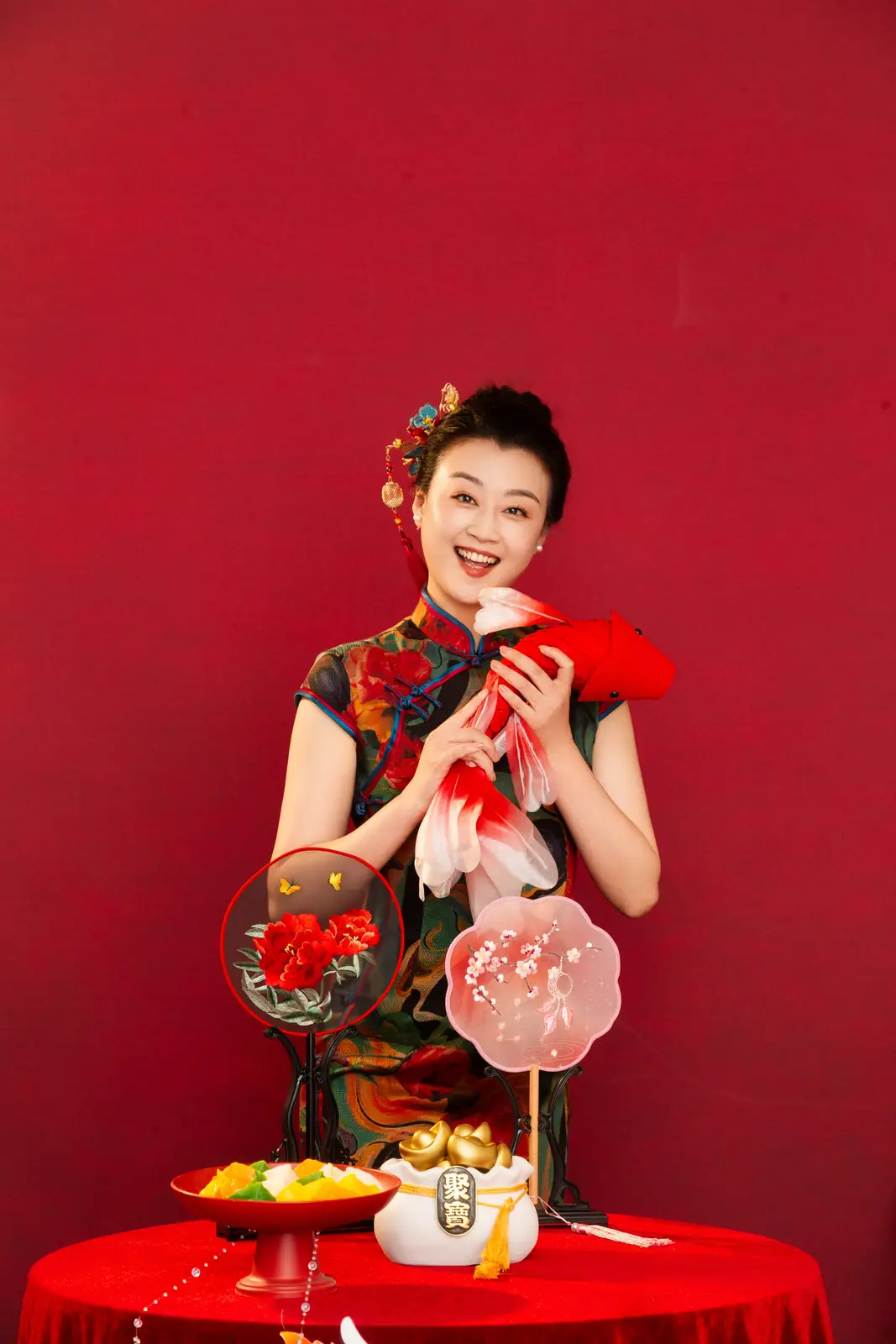 Raina in a floral qipao holding traditional props